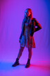 © Ольга Новицкая - full-length portrait of a girl. Model in coarse boots, light chiffon dress and leather jacket. colored background. blue, red, purple light on background and person