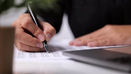 Poster - A man signs a contract. Close up. Business deal concept meeting. A man signs a contract. A male hand with a pen makes notes in the office.