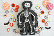 Piñata de esqueleto de Halloween con caramelos alrededor