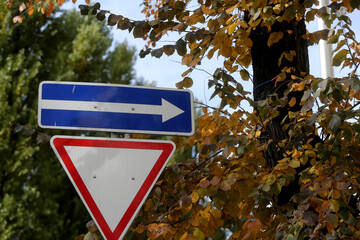 One way street in direction of arrow road sign isolated on black.