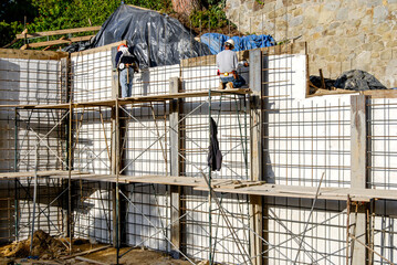 Wall Mural - Construction worker on a scaffold working on a retaining wall