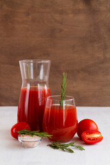 tomato juice and fresh vegetables on the white background. glass of tomato juice with rosemary and salt on the table with copy space