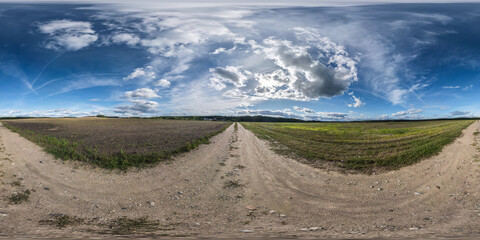 Wall Mural - 360 hdri panorama on no traffic sand gravel road among fields with blue sky with clouds in equirecta