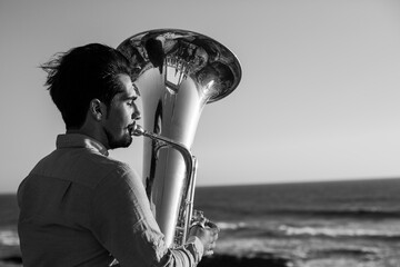 A musician man with a tuba on the Miramar beach, Portugal. Black and white photo.