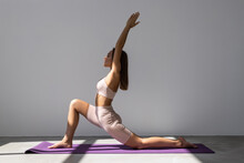 Young Woman In Black Dress Doing Advance Yoga Master On Blue Mat And White Advance