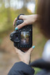 female photographer making landscape photo in autumn forest, selective focus