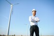 © Serhii - Engineer is checking energy production on wind turbine. Worker in windmills park in helmet.