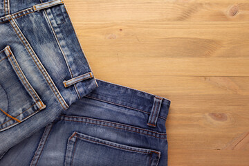 Wall Mural - Blue jeans denim pocket on wood table. Jeans heap at wood background texture