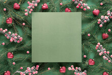Green Red Christmas Background With Square Copy-space, Place For Text. Natural Xmas Twigs Decorated With Frosted Berries And Sparkling Hearts. Flat Lay, Top View On Dark Green Paper.