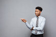Business Concept - Confident thoughtful young African American pointing finger on side over grey background.