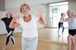 © JackF - Portrait of cheerful senior woman enjoying active dancing during group training in dance studio.
