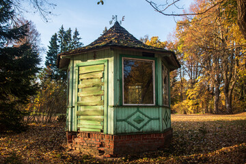 Wall Mural - Small, green wooden gazebo in autumn evening.