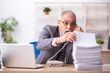 © Elnur - Old male employee working at workplace