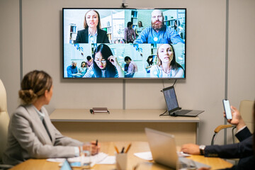 Sticker - Several business people on large display hanging on wall of boardroom where group of employees having webinar