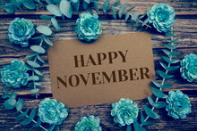Happy November Typography Text On Paper Card Decorate With Flower On Wooden Background