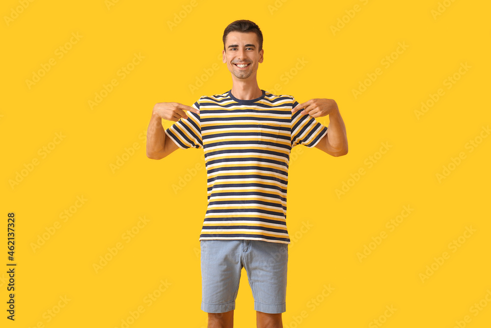 Handsome young man in stylish t-shirt on color background