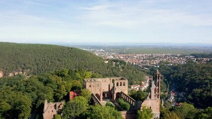 Wall Mural - Flying backwards above the monastery ruin 'Kloster Limburg' with Bad Dürkheim in the background on a sunny day in Germany. 4k Aerial view