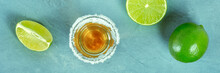 Tequila Shot With Lime Slices Panorama, A Mexican Drink With A Salt Rim, Overhead Flat Lay Shot Panoramic Banner On A Blue Background