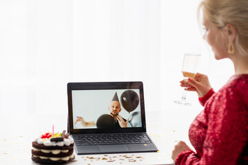 Sticker - Virtual birthday. Festive greeting. Online party. Unrecognizable woman with glass champagne holiday cake looking congratulating man on laptop isolated white.