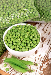 Poster - Green pea in bowl of top view on rustic wooden background with copy space, natural wooden table.