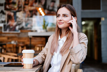 Thoughtful Businesswoman With Disposable Cup At Coffee Shop Terrace