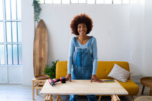 Redhead Afro Woman Standing At Table In Living Room