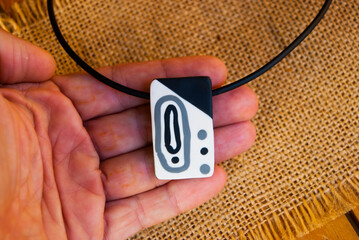 Wall Mural - Rectangle modern pendant in woman hand. Polymer clay jewelry.