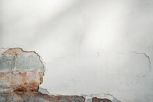 Old White Wall With Chipped Away Paint And Brick Detail