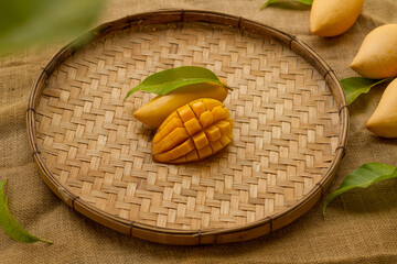 Sticker - Fresh ripe mango fruit on Thai tradition weave basket with leaves. Mango Dessert and Juice concept.