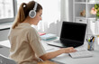 © Syda Productions - education, online school and distant learning concept - student woman in headphones with laptop computer, notebook and book at home