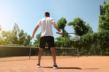 Canvas Print - Man playing tennis on court, back view