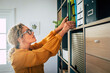 © Westend61 - Mature female professional searching file at home office
