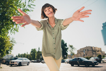 Sticker - Photo portrait female student in casual clothes smiling walking on sunny city streets keeping hands forward embracing friend