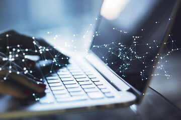 Poster - Close up of hand using laptop at desktop with glowing polygonal mesh on blurry background. Technology, network and connections concept. Double exposure.