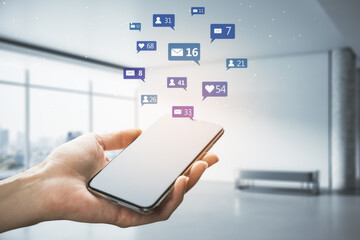 Poster - Close up of female hand using smartphone with social media icons on blurry bright office interior background. Communication, network, connections, device and app concept.