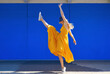 © VISTA by Westend61 - Carefree woman dancing by blue wall on sunny day