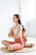 © Вадим Каштанов - Young woman and little girl sit in lotus position back to back. Morning yoga practice.