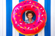© VISTA by Westend61 - Cute smiling boy looking through inflatable doughnut
