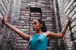 © VISTA by Westend61 - Confident female dancer with arms outstretched amidst stone walls