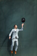 © VISTA by Westend61 - Male professional jumping while throwing hat against wall