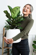© Rawpixel.com - Happy woman carrying a houseplant