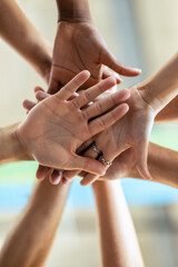 Hands of successful smart business team celebrating good job while holding up their right hands on coworking place.