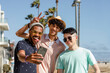 Teen boys taking selfie, enjoying summer together outdoors in Venice Beach, Los Angeles