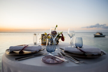 Wall Mural - Romantic dinner setting on the beach at sunset