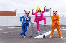 Funny Characters Wearing Animal Masks And Colored Business Suits Having Fun On Empty Parking Lot