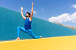 © VISTA by Westend61 - Man with arms raised practicing yoga on retaining wall during sunny day