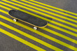 © VISTA by Westend61 - Skateboard on striped yellow road marking