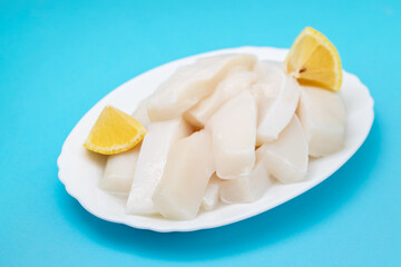 Wall Mural - raw squid with pepper and fresh lemon on white dish