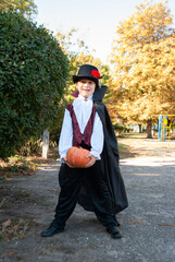 Wall Mural - malik in a vampire costume on halloween depicts a pumpkin