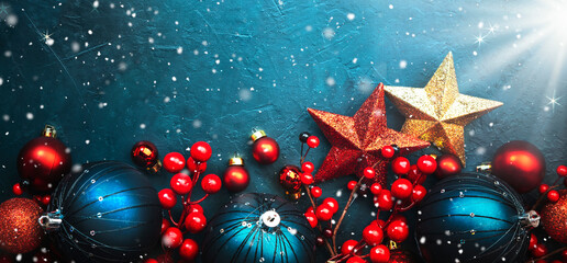 Wall Mural - Blue Christmas or New Year background with blue Christmas balls, red berries and stars with snowflakes, top view, place for text banner